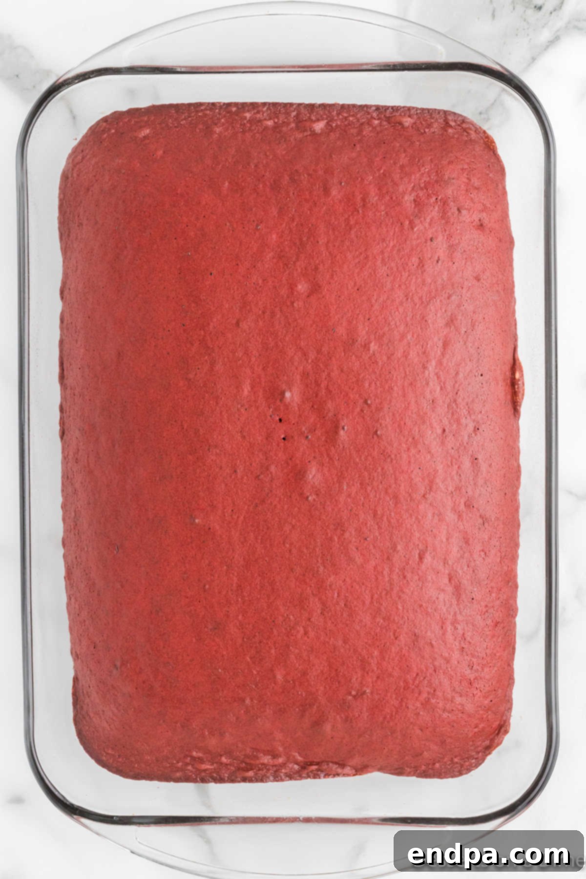 Red velvet cake baked in a square pan, freshly out of the oven.