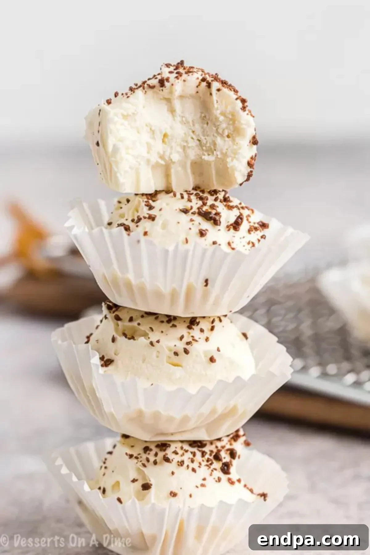 Stacked Keto Cheesecake Fat Bombs in cupcake holders, showcasing their rich, creamy texture and perfect portion size for a guilt-free low-carb dessert.