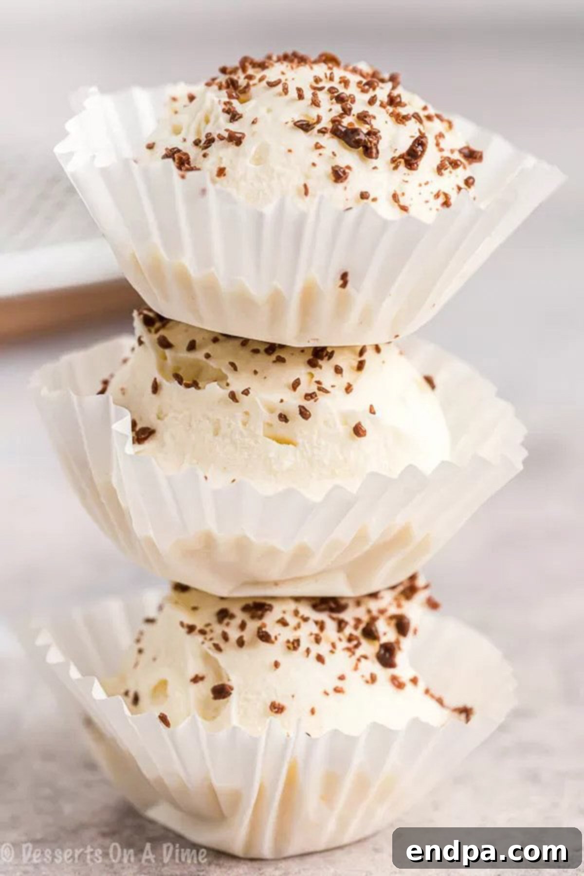 A pyramid stack of Keto Cheesecake Fat Bombs, each perfectly set in a cupcake holder, highlighting their delicious appeal and readiness to be enjoyed as a low-carb, high-fat snack.