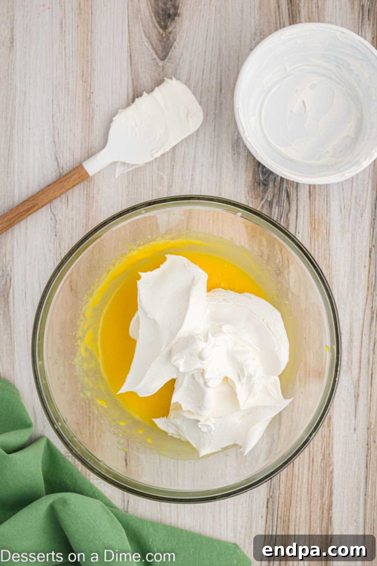 Super Fluffy Cool Whip Frosting 4 Thawed Cool Whip being gently added to the thickened pudding mixture.