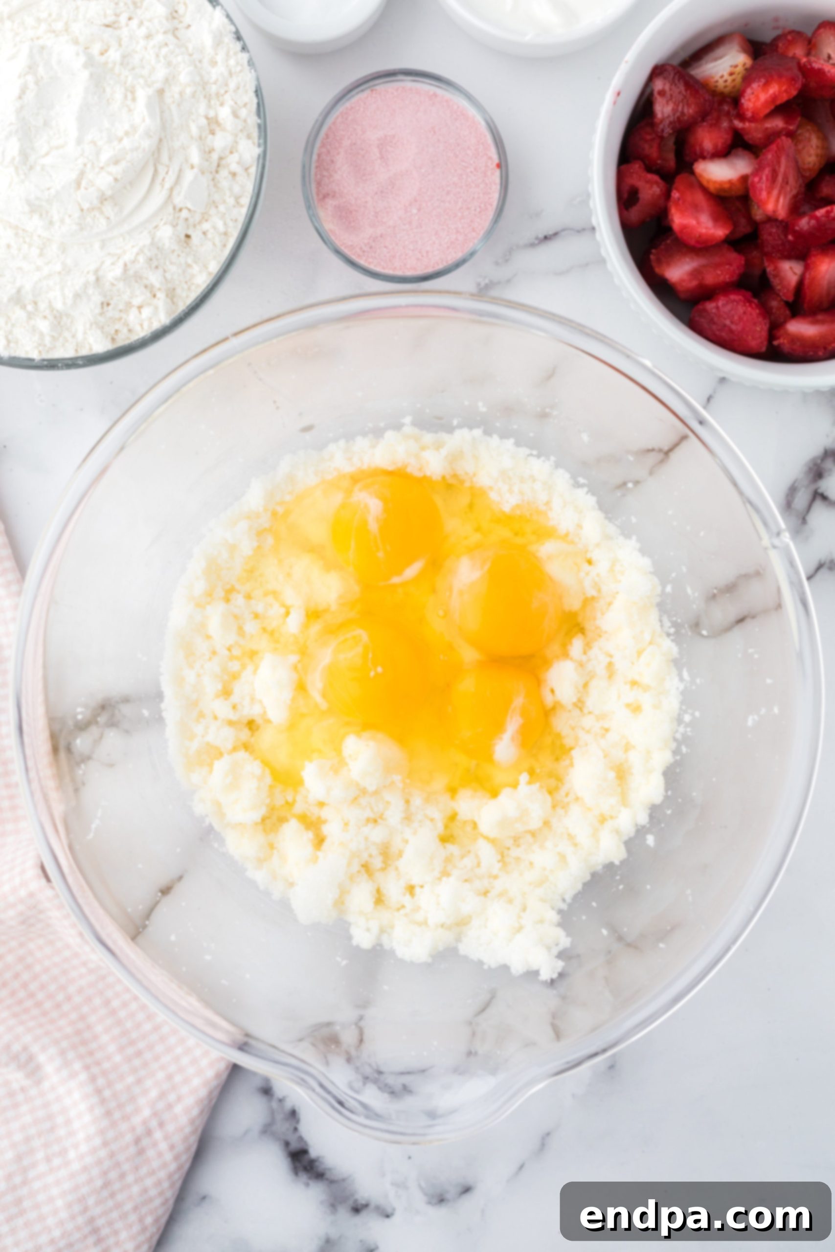 Zesty Strawberry Lemon Bundt Delight 4 Eggs in bowl with sour cream and milk.
