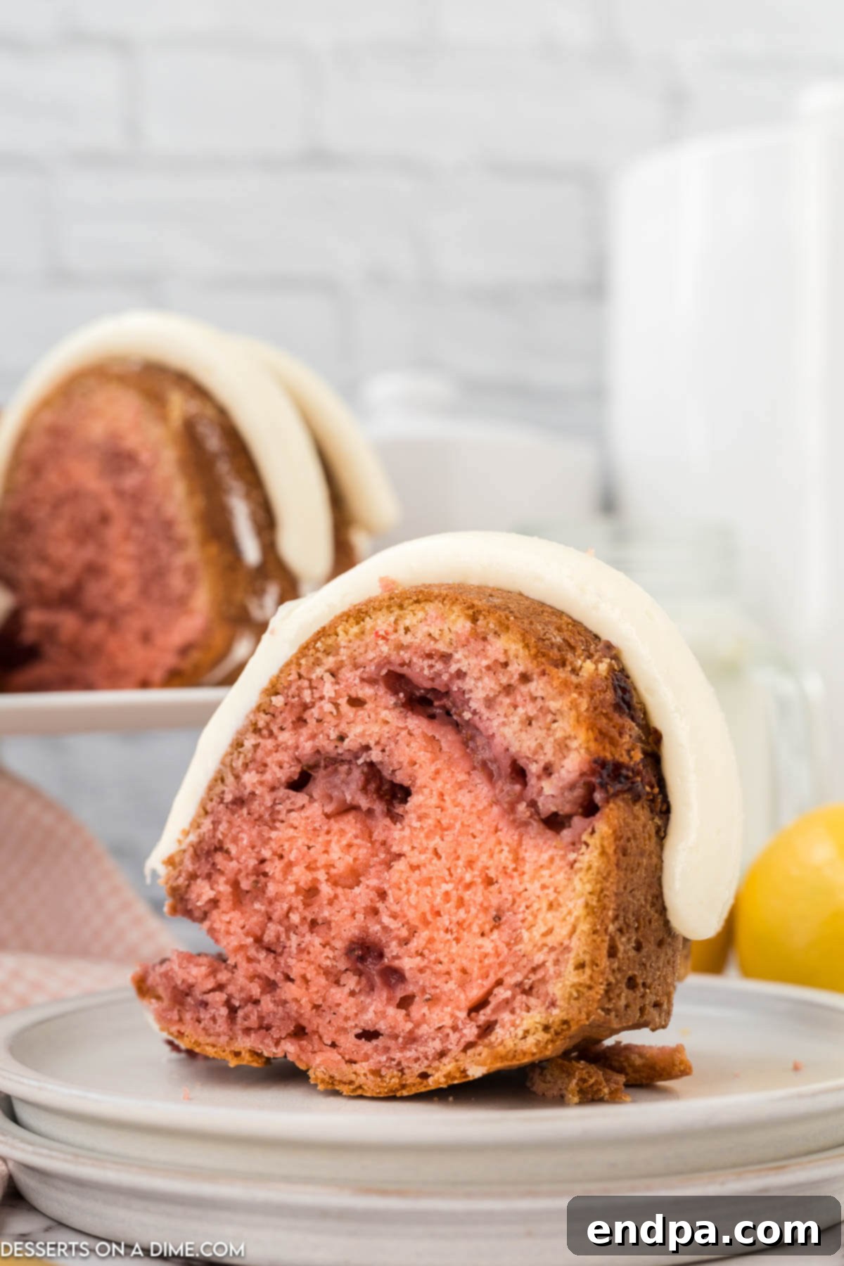 Zesty Strawberry Lemon Bundt Delight 10 Strawberry lemonade bundt cake sliced on plate.