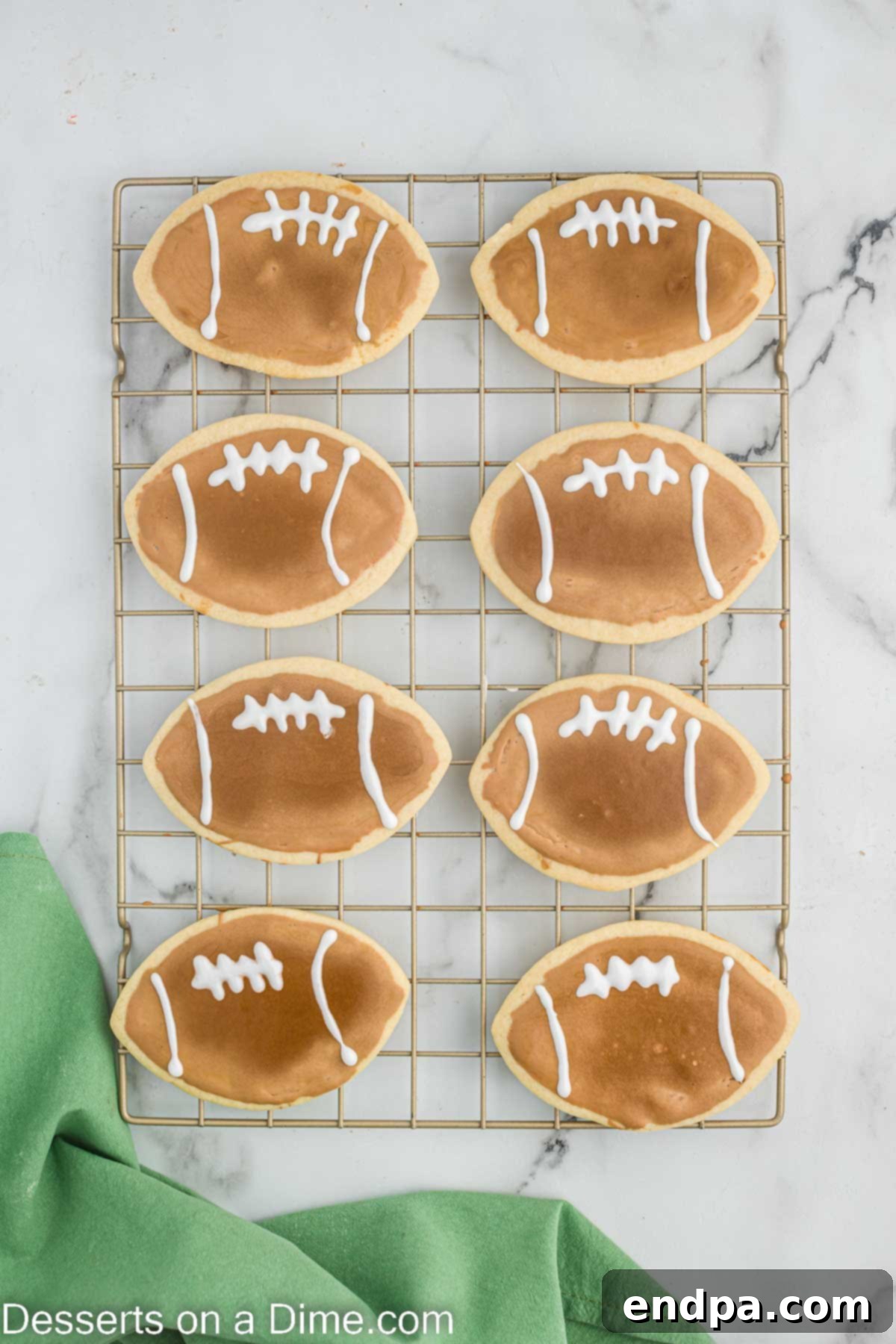 Touchdown Sugar Cookies 4 Freshly baked football sugar cookies cooling on a wire rack, perfectly shaped and ready for the icing decoration process.