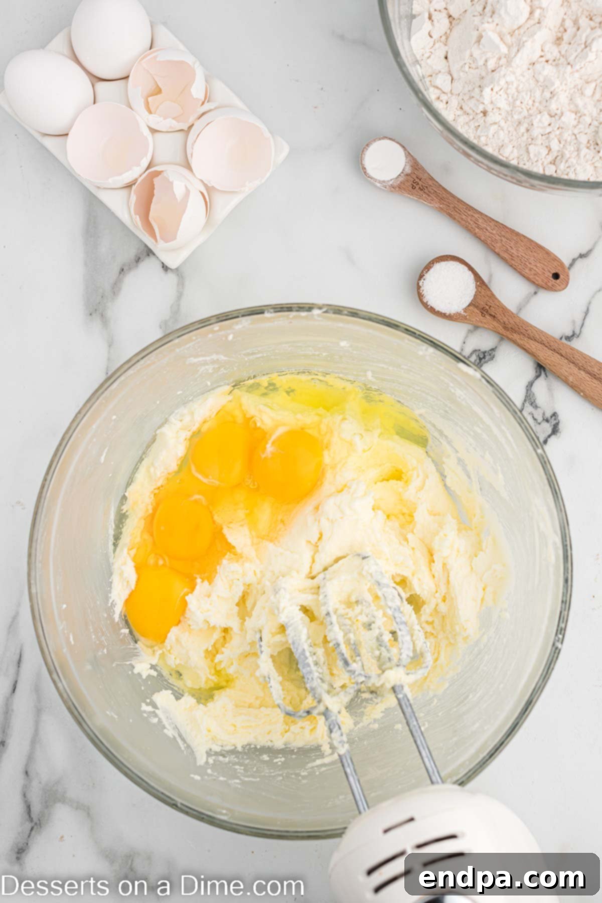Touchdown Sugar Cookies 6 Large eggs being added into the creamed butter and sugar mixture.