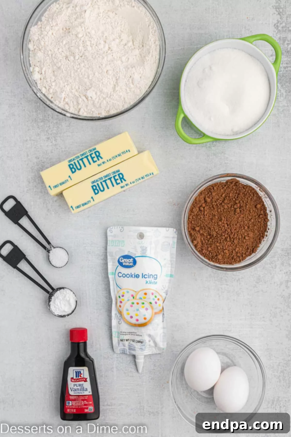 Championship Chocolate Football Cookies 3 A flat lay of ingredients for making Chocolate Football Cookies including flour, baking powder, butter, sugar, vanilla extract, cocoa powder, and white icing.