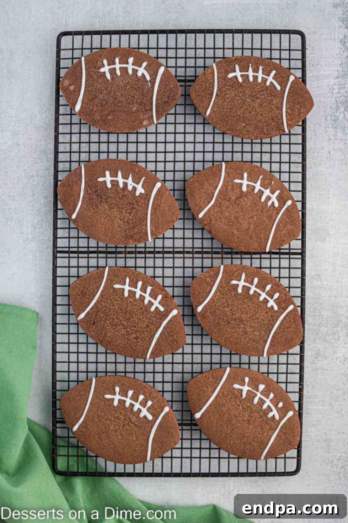 Championship Chocolate Football Cookies 10 Baked chocolate football cookies cooling on a wire rack after being removed from the baking sheet.