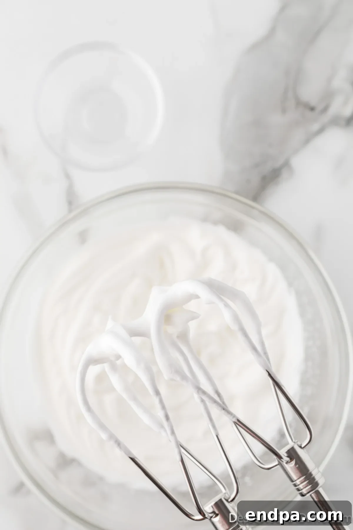 Velvety Chocolate Bliss 11 A whisk attachment lifted from whipped egg whites, clearly showing perfectly formed stiff peaks that stand upright.