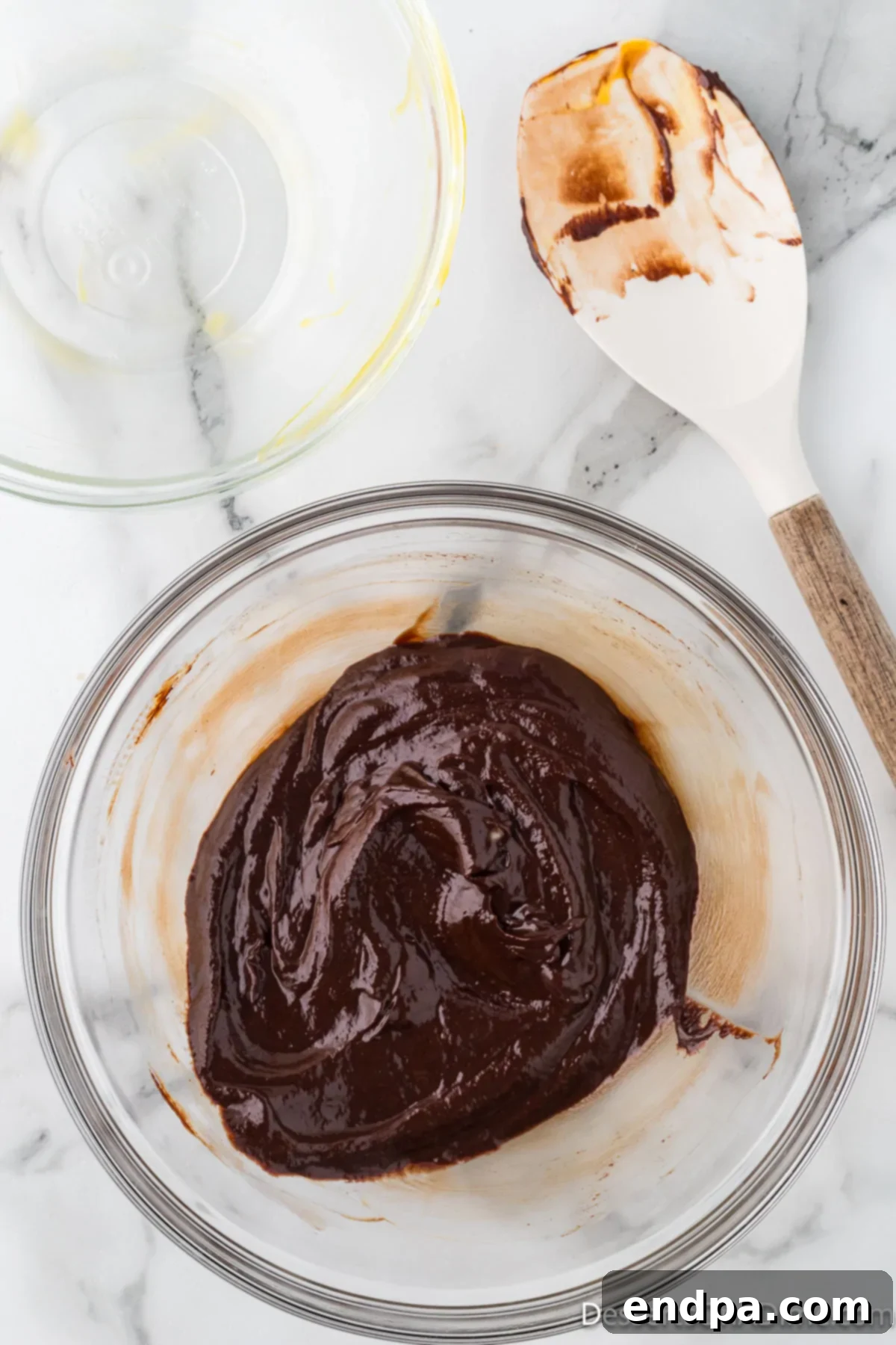 Velvety Chocolate Bliss 8 A bowl showcasing a perfectly blended, glossy chocolate and egg yolk mixture, smooth and unified.