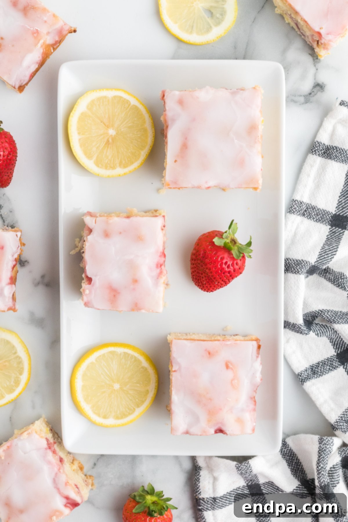 Beautifully arranged Strawberry Lemon Blondies on a white platter, showcasing their vibrant colors and luscious glaze.