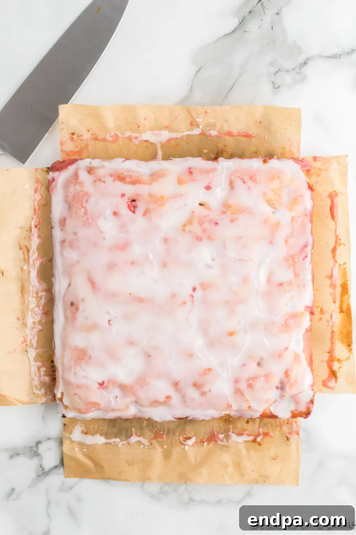 Glazed Strawberry Lemon Blondies cooling in the pan, ready for slicing.