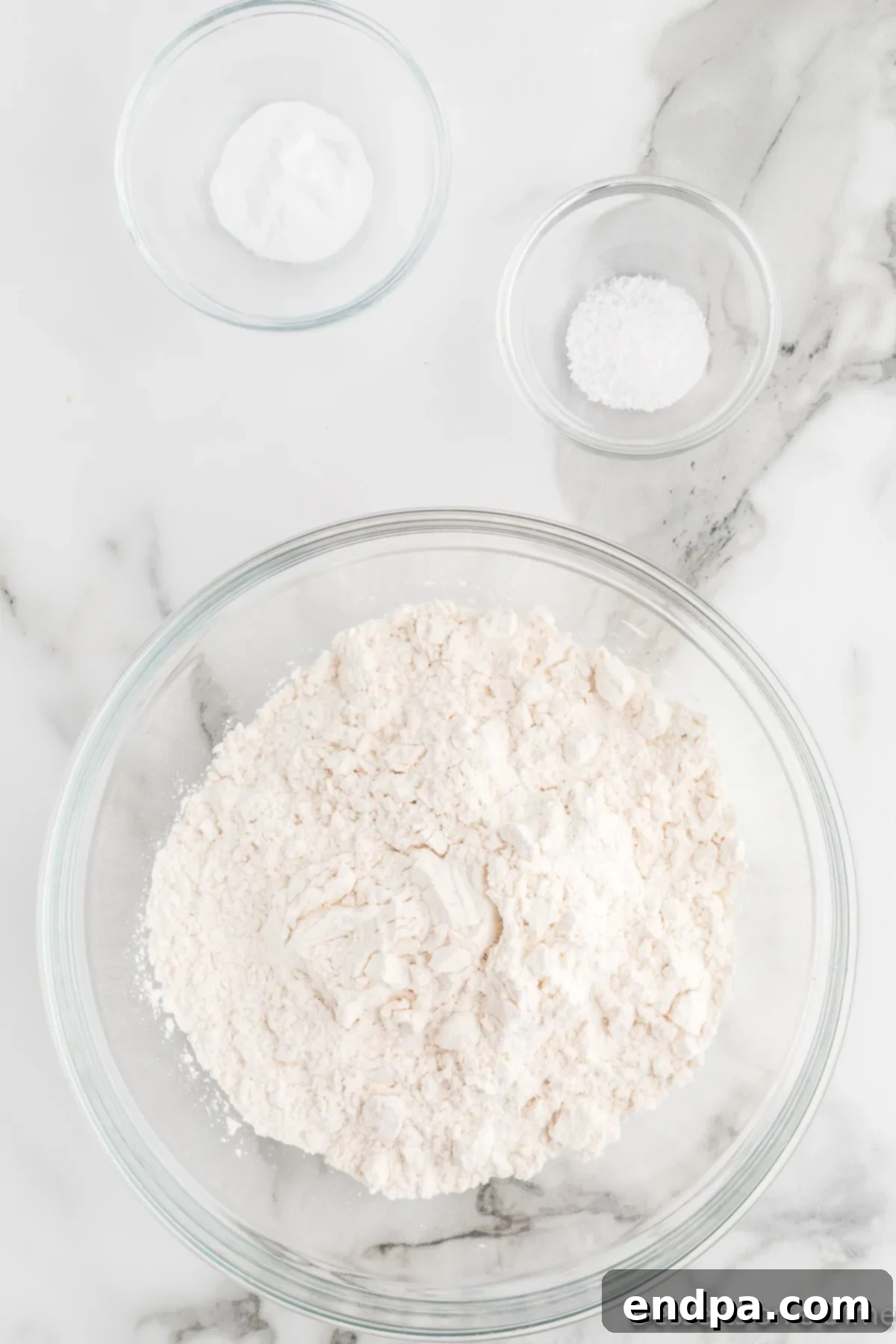 Mixing bowl with flour, baking powder, and salt, ready to be combined.