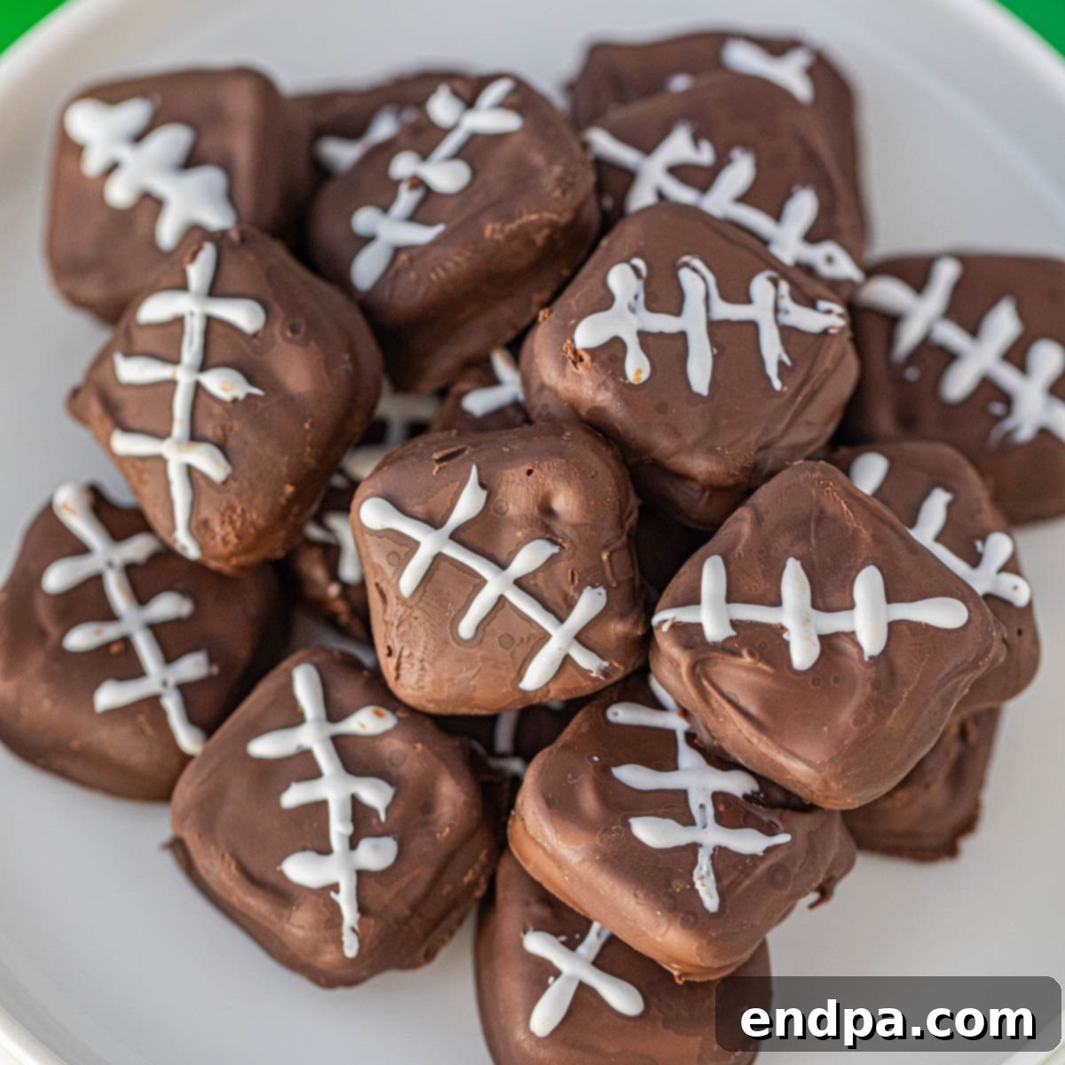 Chocolate covered footballs on a white plate, ready to be served.