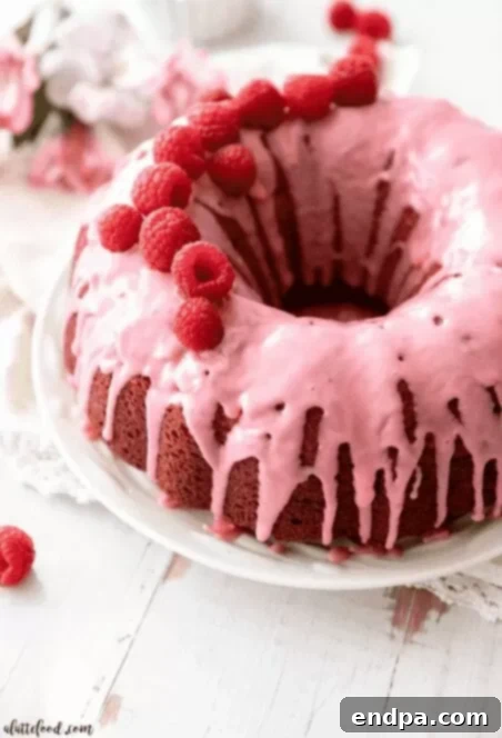 Love Baked Delights 28 Raspberry Bundt Cake slice with fresh raspberries.