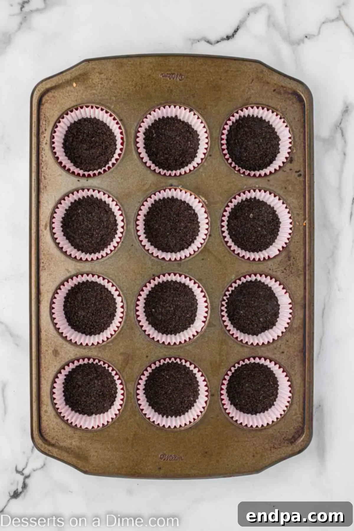 Petite Red Velvet Cheesecakes 5 Cookies crushed and placed into muffin cups.