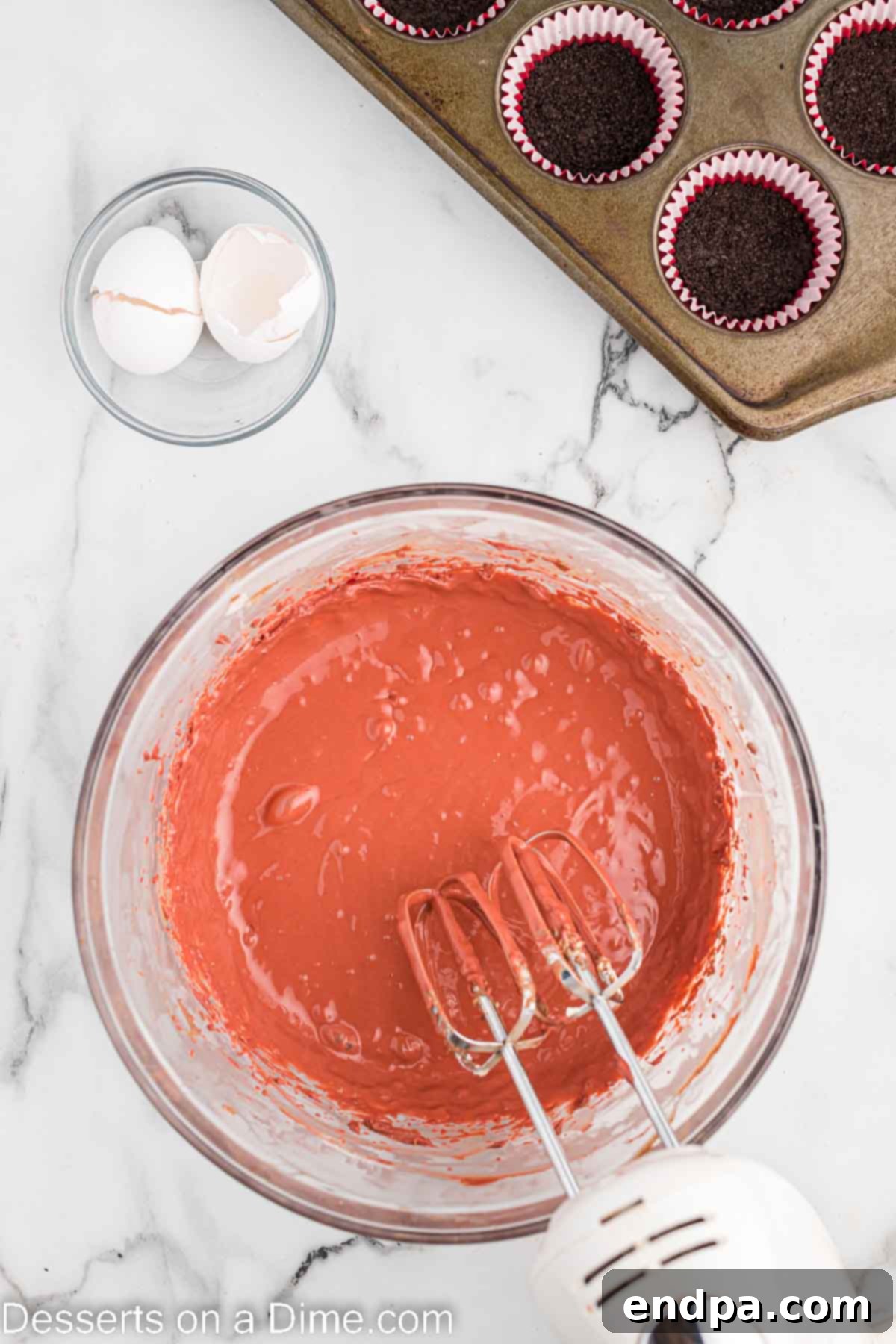 Petite Red Velvet Cheesecakes 6 Batter combined in a bowl for cheesecake filling.