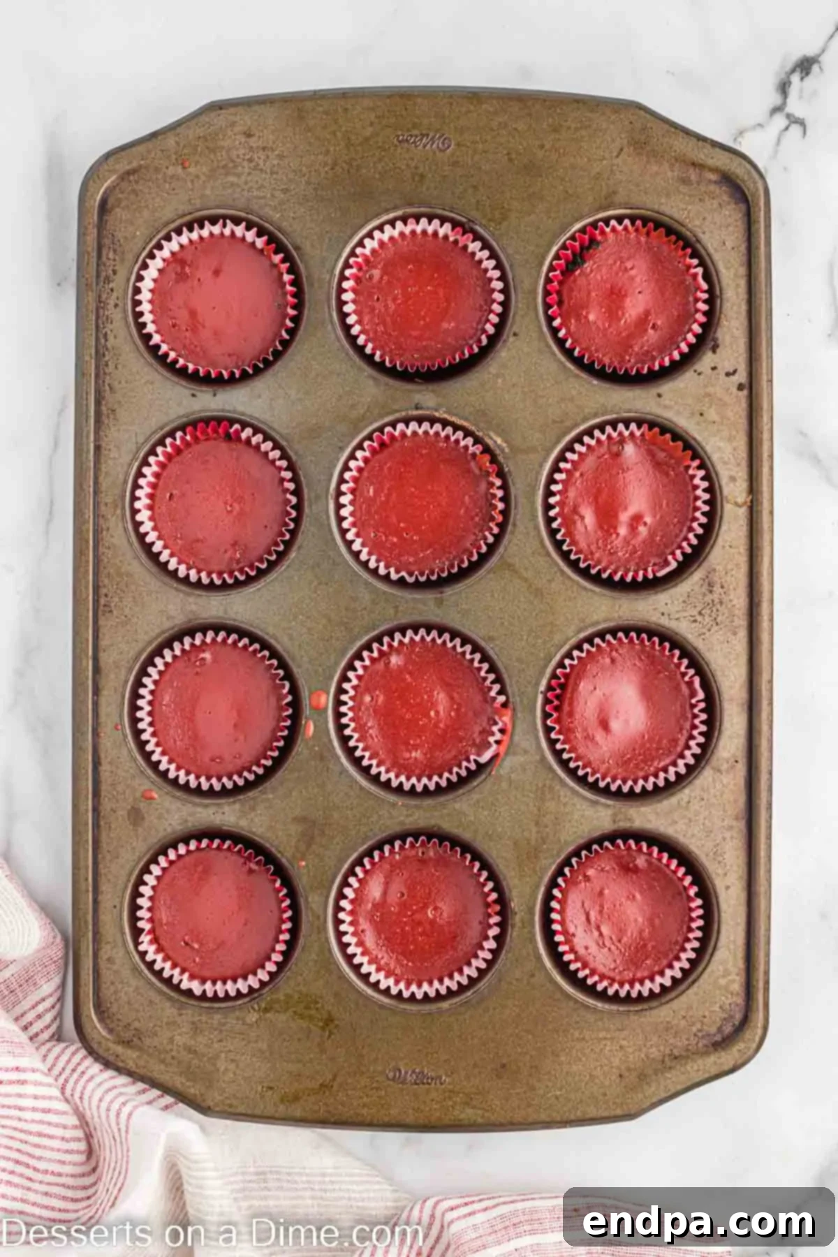 Petite Red Velvet Cheesecakes 7 Batter poured into muffin tins on top of cookie crust.