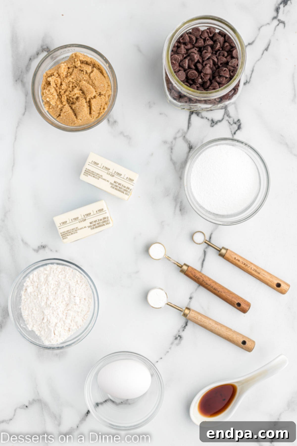A selection of raw ingredients for air fryer chocolate chip cookies, including softened butter, brown sugar, granulated sugar, eggs, vanilla extract, all-purpose flour, baking soda, and semi-sweet chocolate chips.