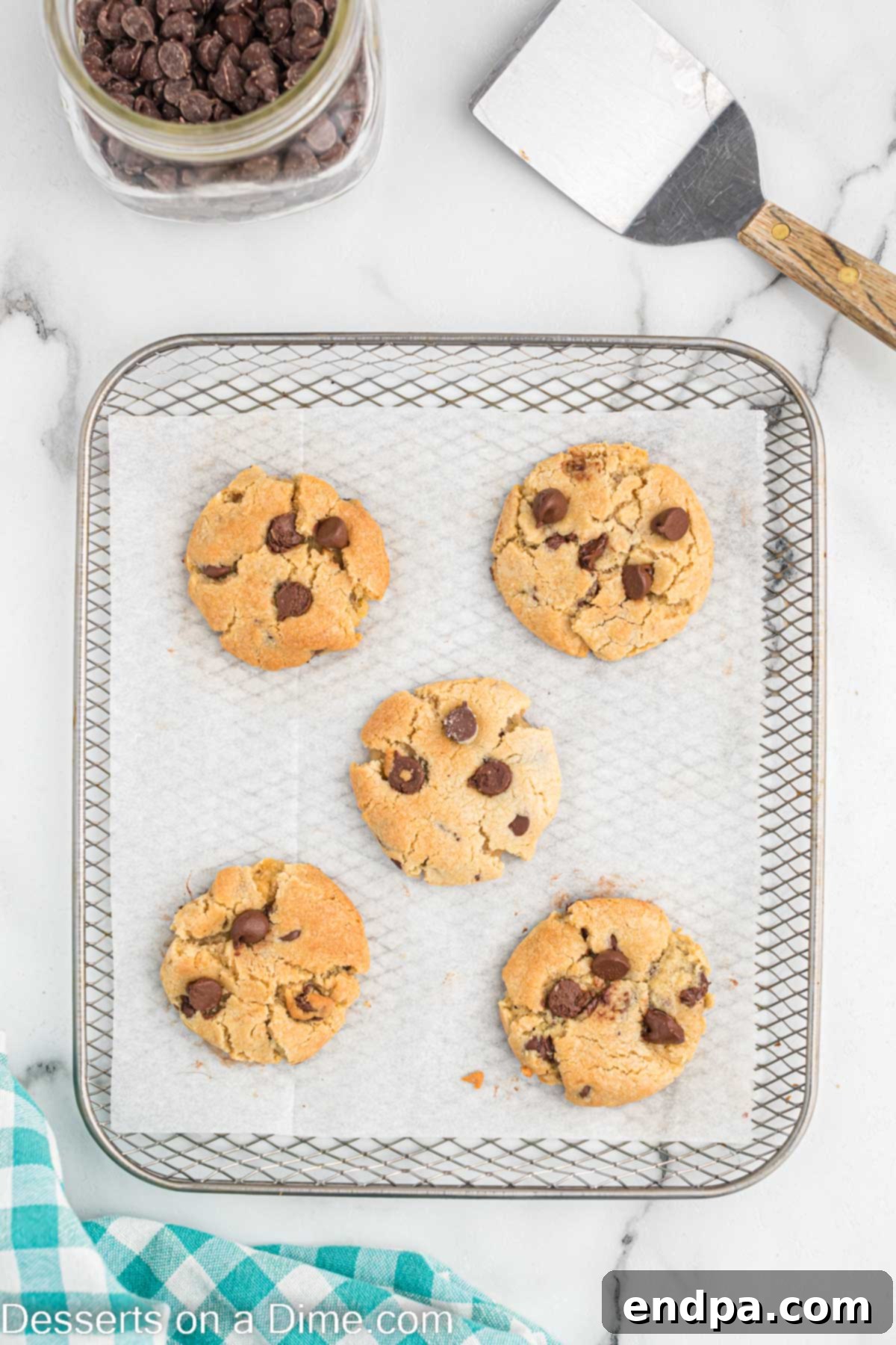 Freshly baked air fryer chocolate chip cookies, golden brown and still in the air fryer basket.