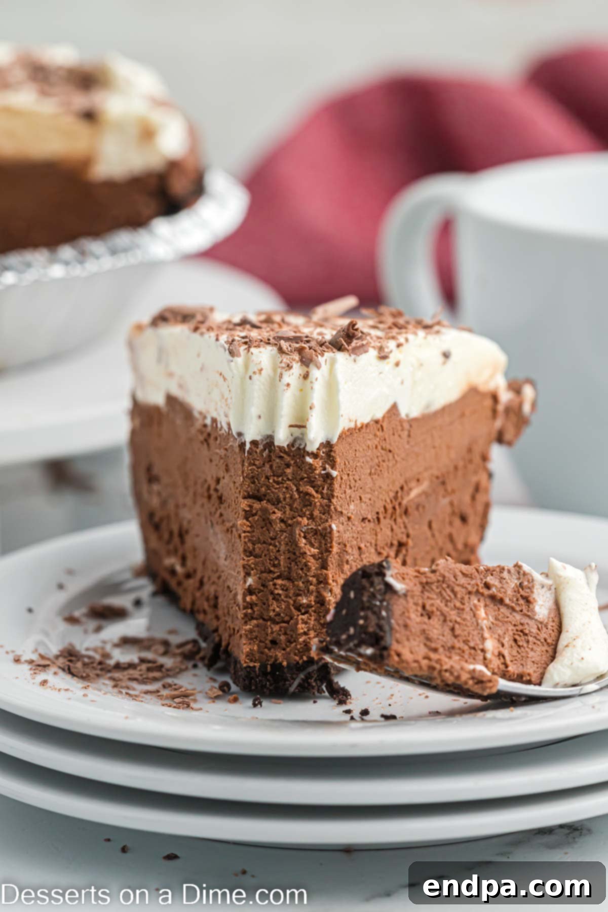 Decadent Chocolate Mousse Delight 2 A slice of chocolate mousse pie on a white plate, showcasing its creamy texture and chocolate shavings on top.