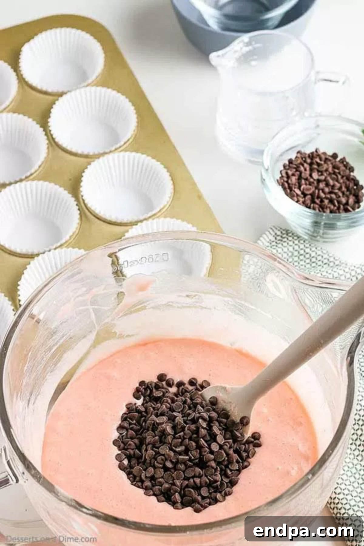 Watermelon Splash Cupcakes 3 Mini chocolate chips being folded into the pink cupcake batter.