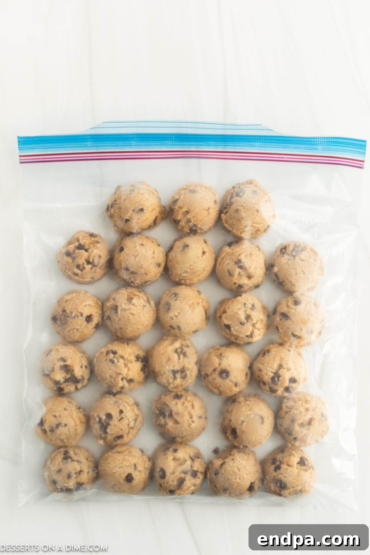 Effortless Cookie Prep: Freezing Dough for Later 3 Frozen cookie dough balls safely stored in a clear freezer bag, ready for future baking.