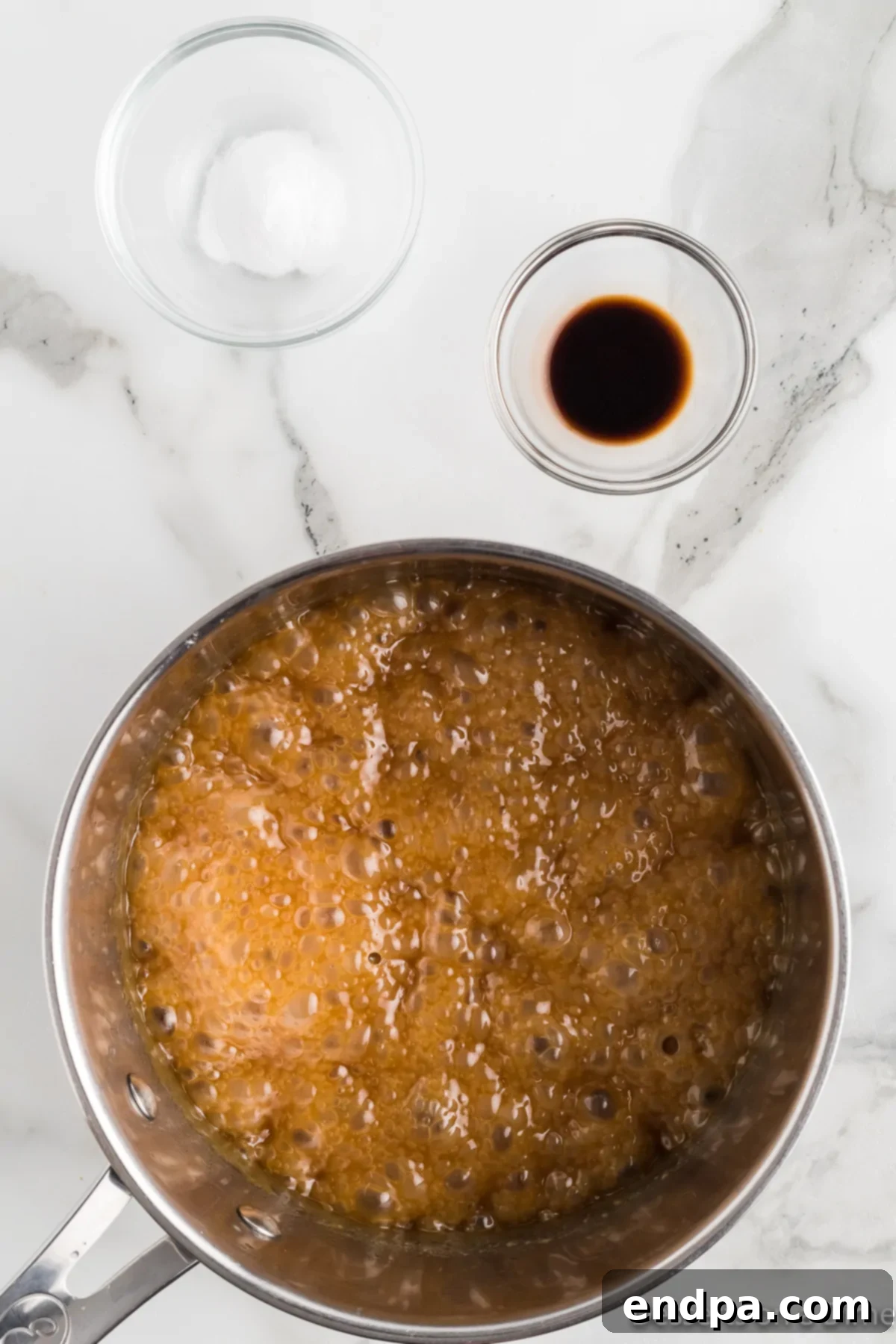 The butter, brown sugar, and corn syrup mixture boiling vigorously in a saucepan. 