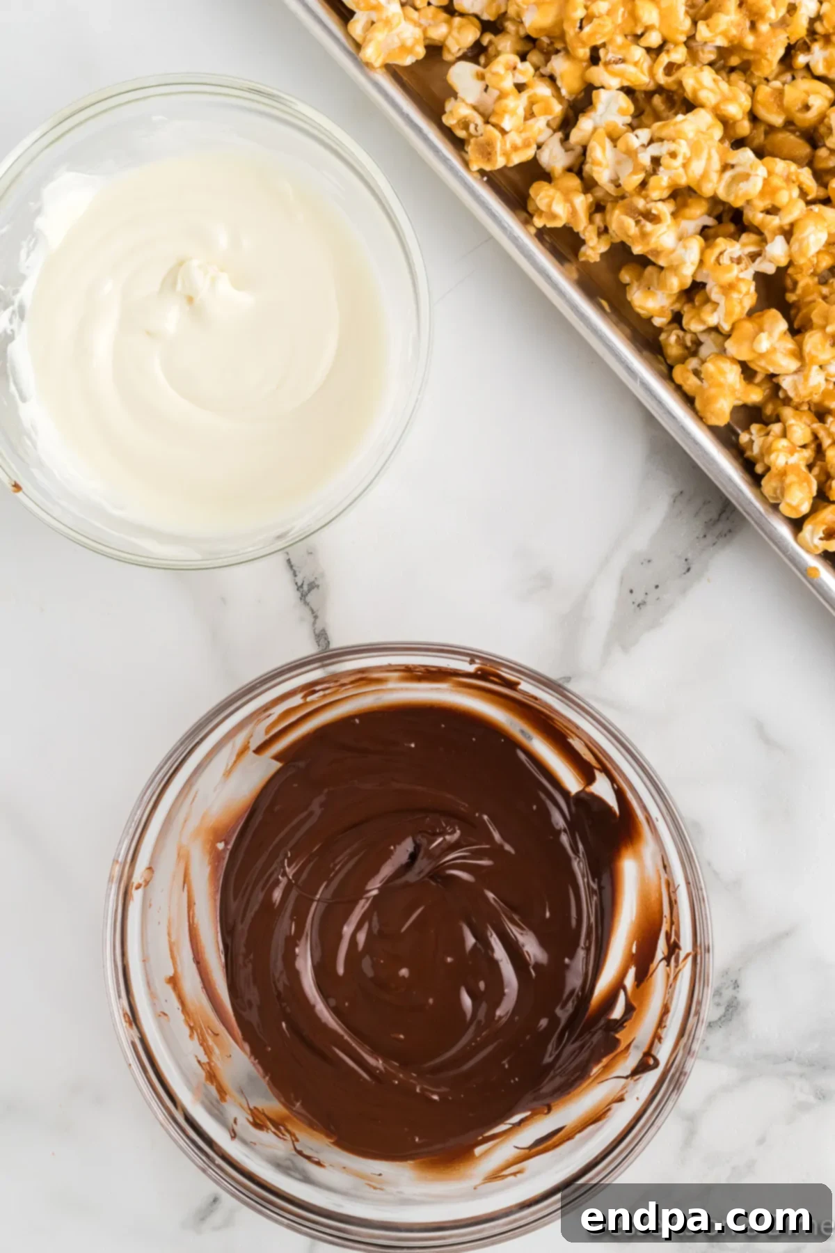 Separate bowls of melted white and dark chocolate, ready for drizzling. 