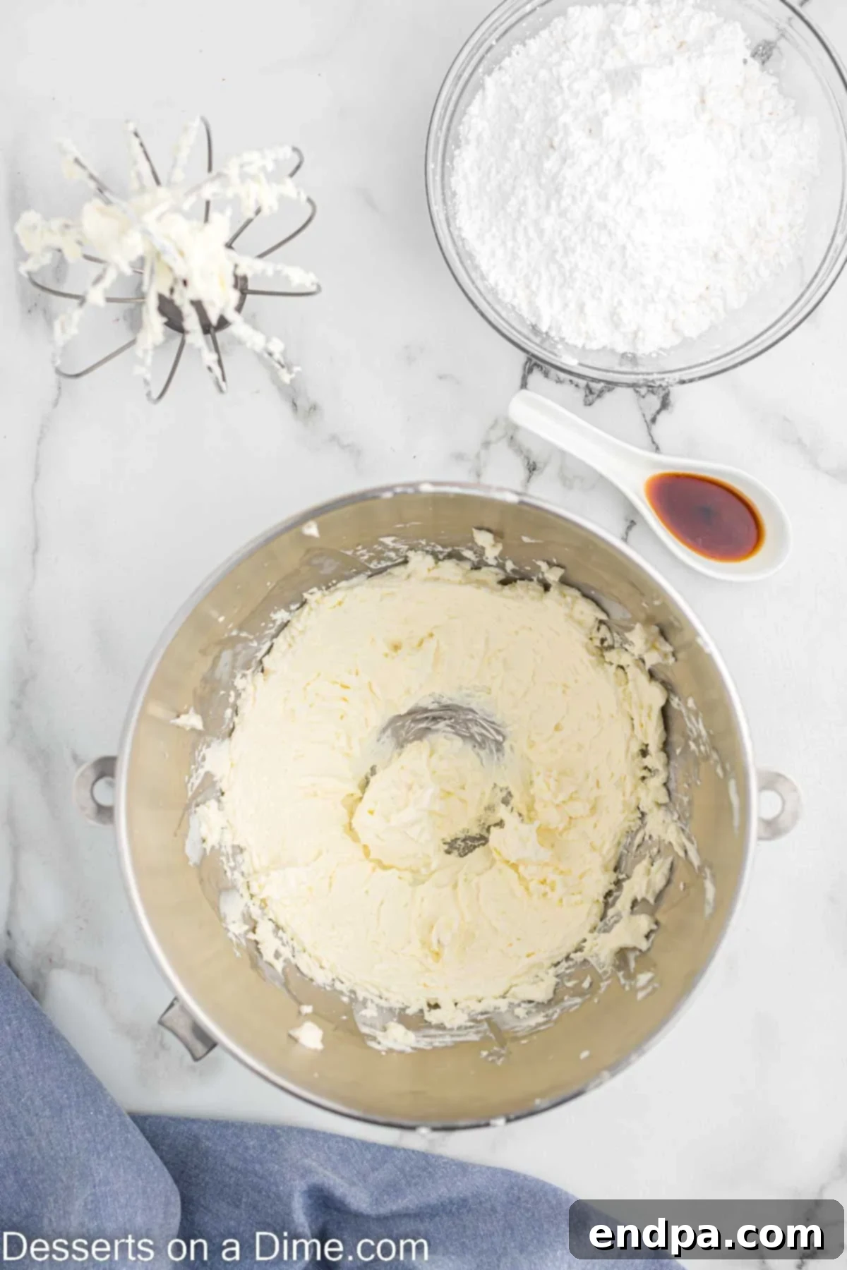 Cream cheese being beaten until soft and fluffy in a stand mixer.