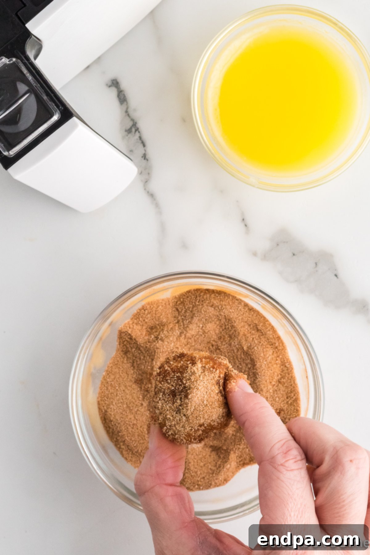 Air Fryer Donut Poppers 9 Several finished air fryer donut holes coated in cinnamon sugar, arranged on a tray.