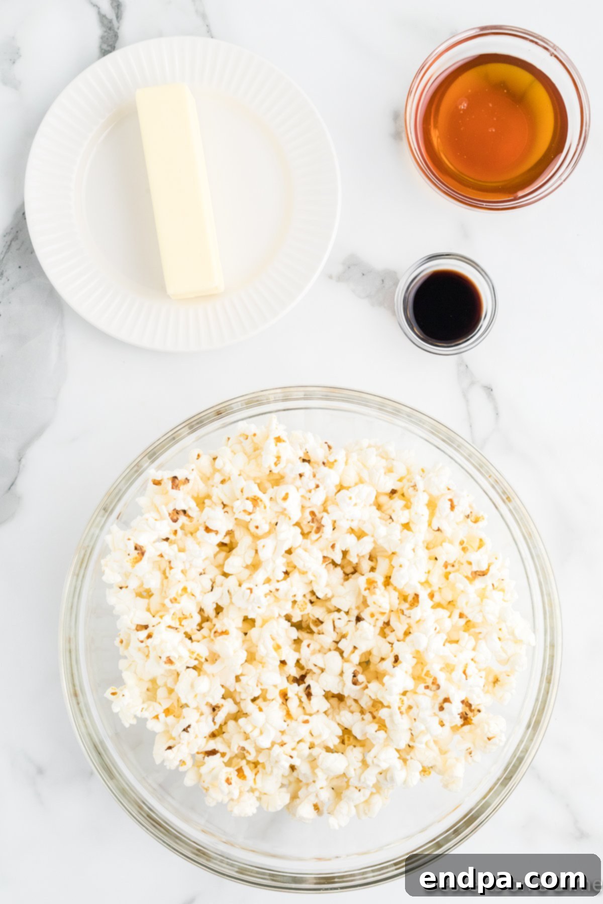 Ingredients for Honey Butter Popcorn recipe - freshly popped popcorn, real butter, pure honey, and vanilla extract.