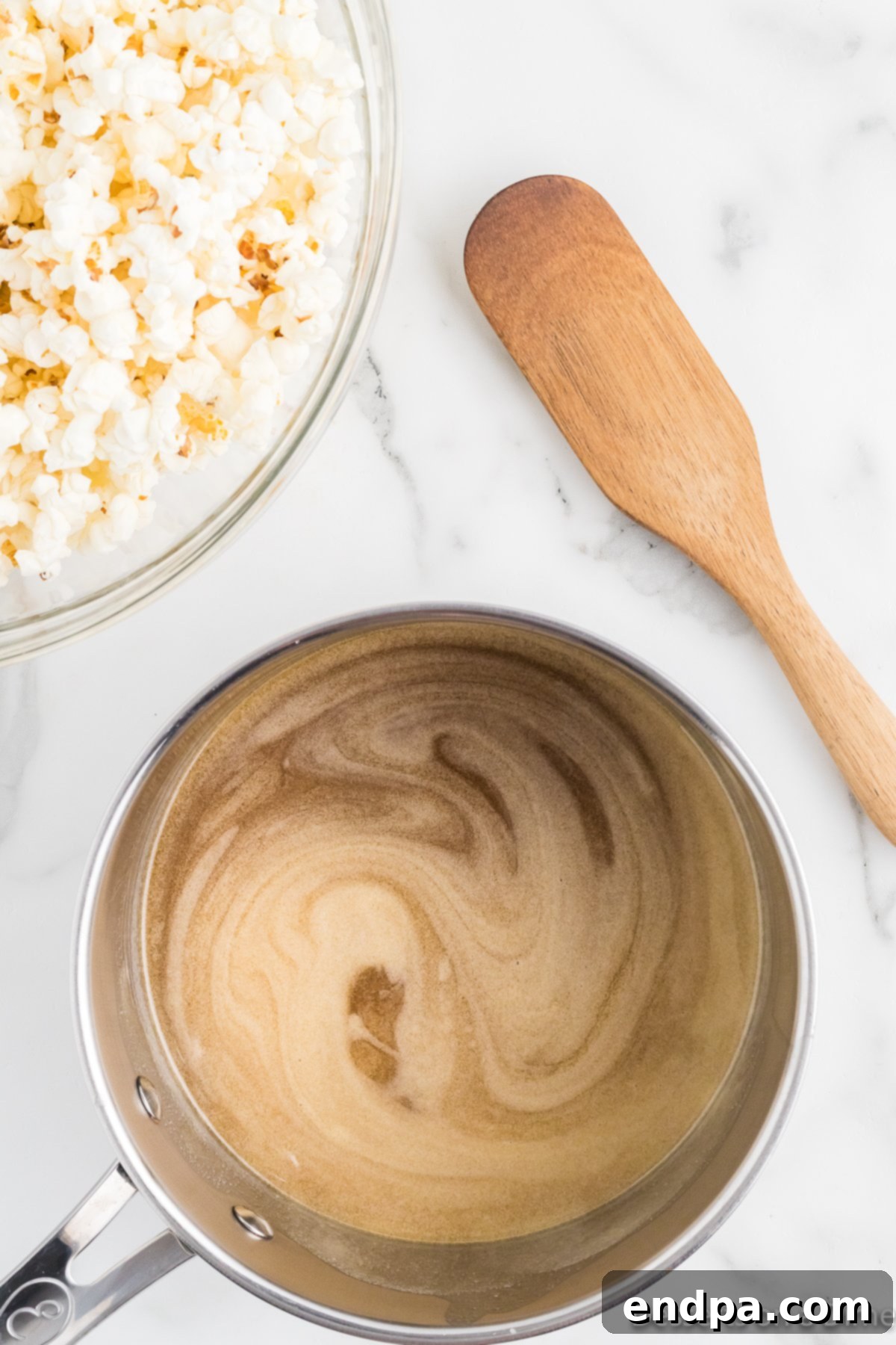Honey butter mixture removed from heat with vanilla extract being stirred in.
