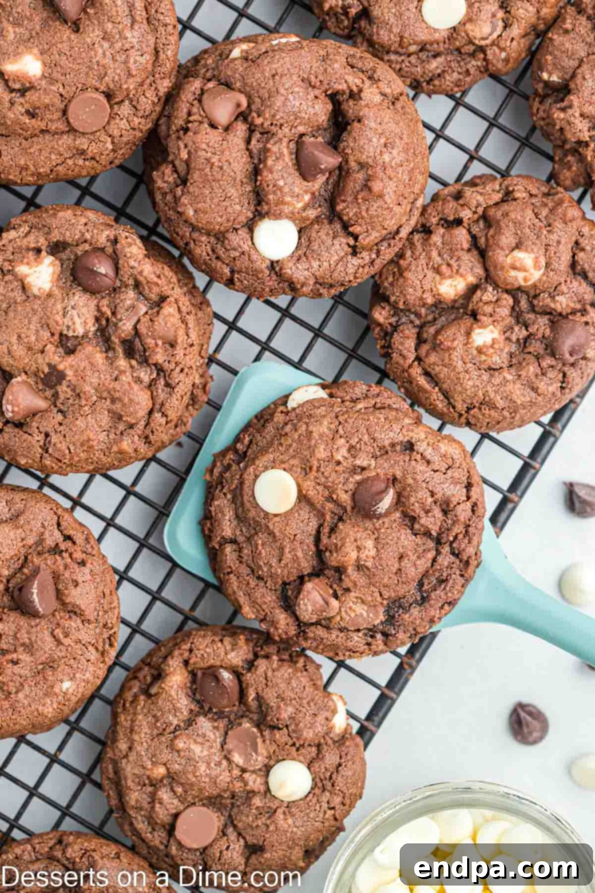 Triple chocolate cookies arranged on a wire rack to cool completely.