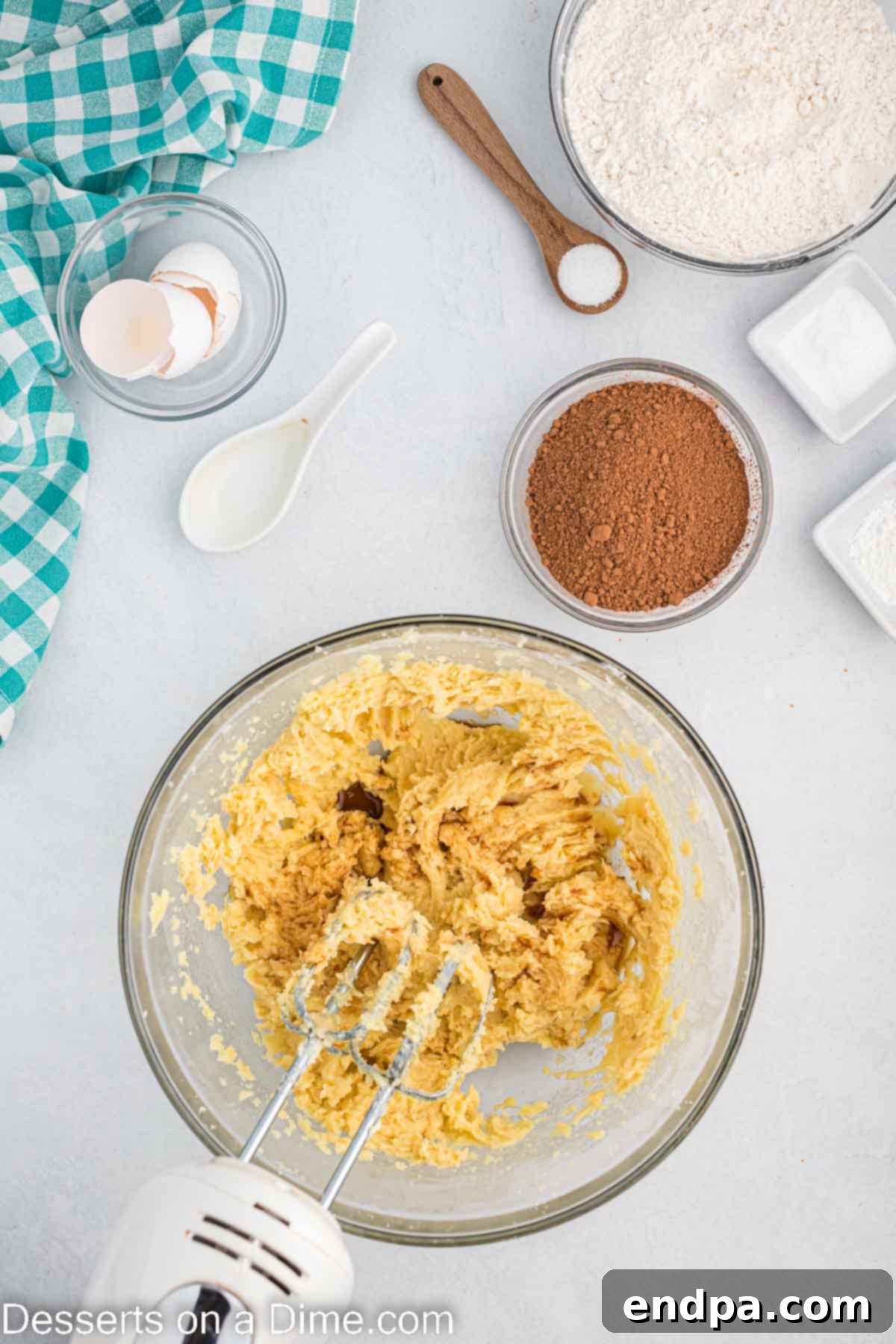 Eggs and vanilla extract being added to the creamed butter and sugar mixture.