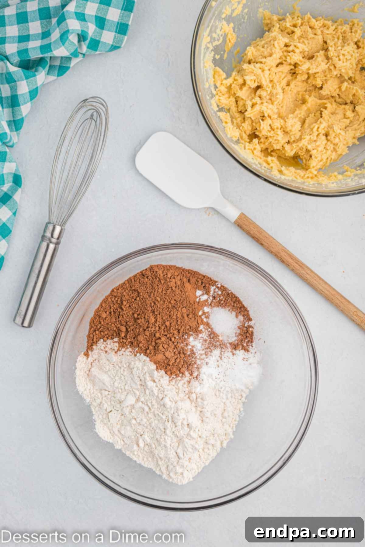 Dry ingredients, including flour, cocoa powder, baking soda, and salt, mixed in a separate bowl.