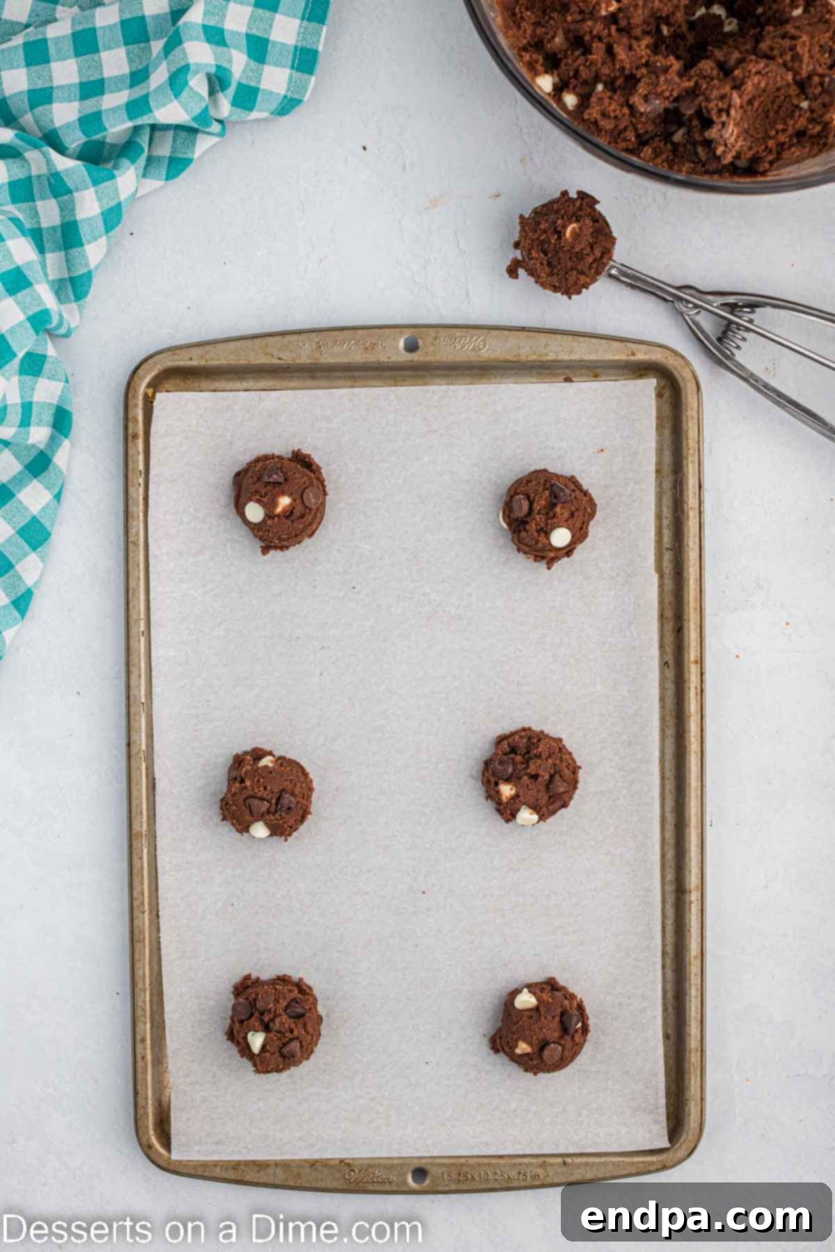 Scooped cookie dough balls placed on a baking sheet, ready for the oven.