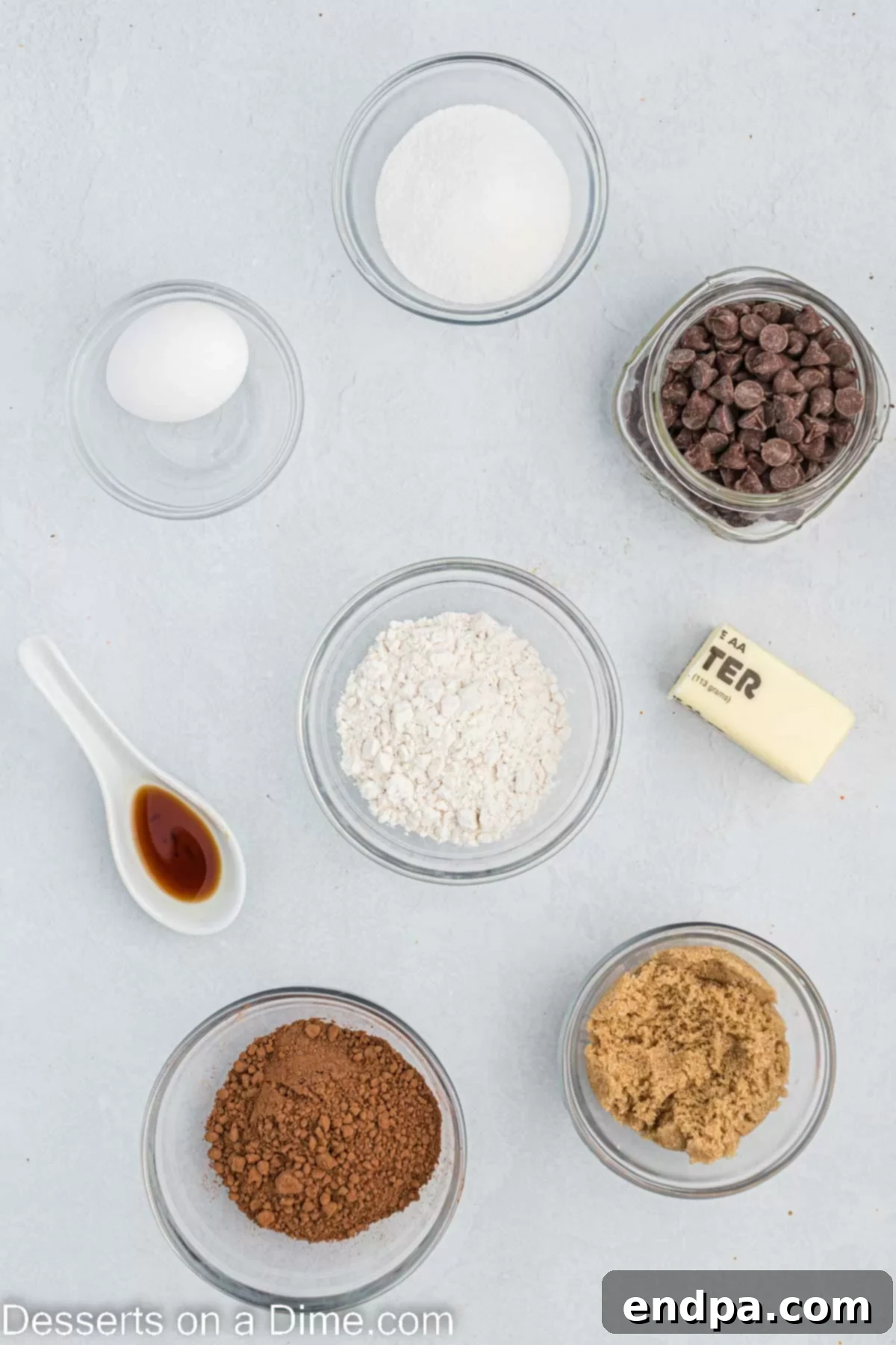 Ingredients for air fryer brownies - brown sugar, cocoa powder, chocolate chips, vanilla, butter.