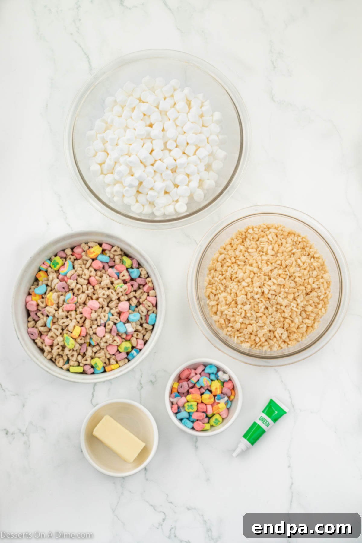 Shamrock Krispie Squares 3 Ingredients for St. Patrick's Day Rice Krispie treats laid out: Rice Krispie cereal, Lucky Charms cereal, butter, mini marshmallows, and green food coloring.
