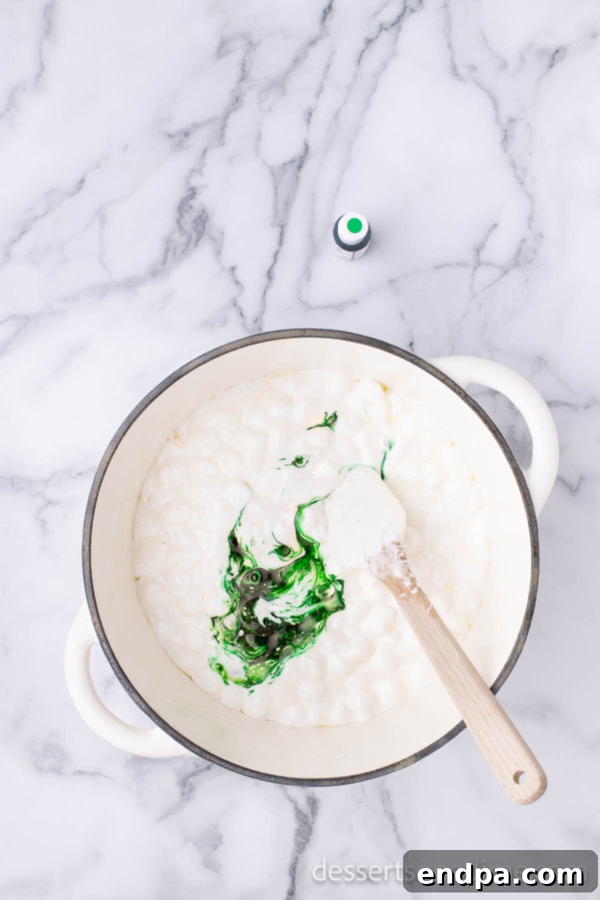 Shamrock Krispie Squares 5 Melted marshmallow and butter mixture in a pot, now vibrant green after food coloring has been added.