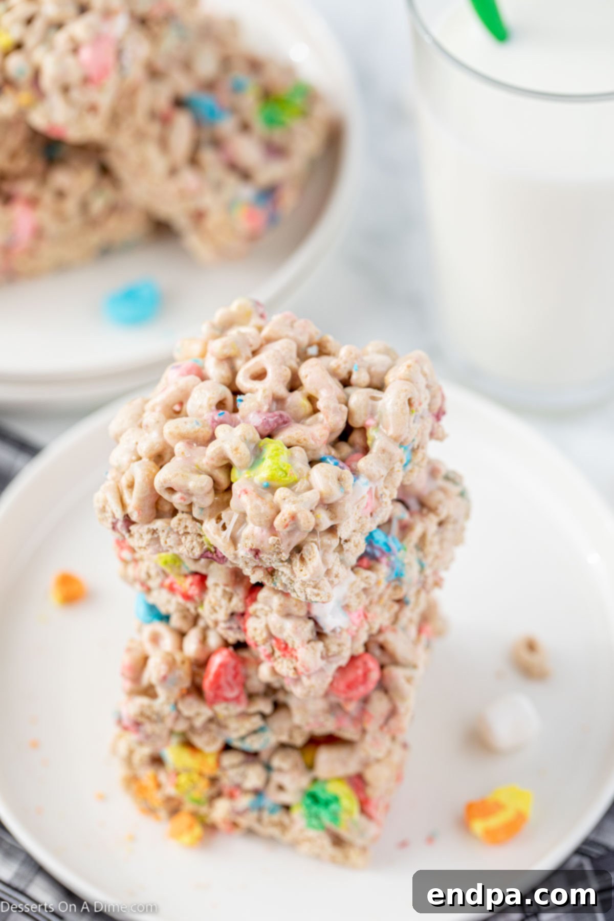 Colorful Lucky Charm Treats cut into squares and stacked together on a plate, ready to be enjoyed.