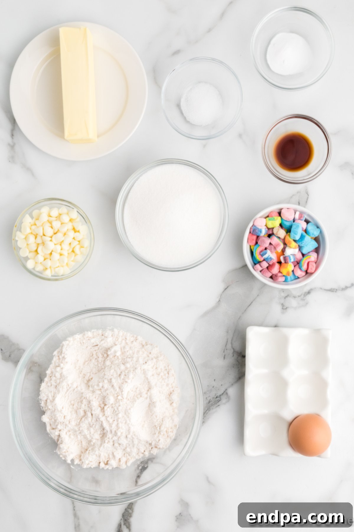 Ingredients for Lucky charm cookies- butter, sugar, eggs, vanilla, flour, baking soda, white chocolate chips, lucky charms cereal. 