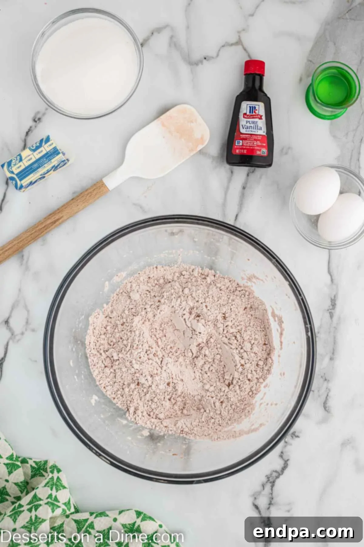 A mixing bowl containing dry ingredients such as flour, baking soda, cocoa, and salt, ready to be combined.
