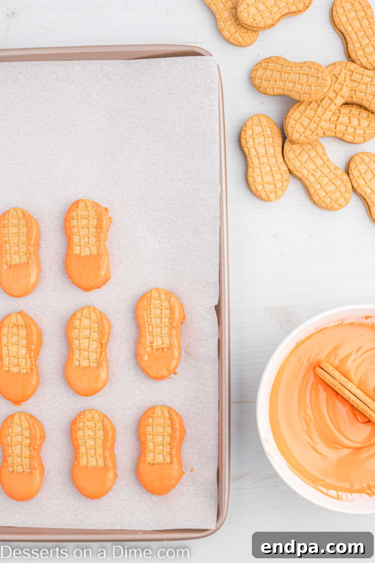 Lucky Leprechaun Bites 4 A Nutter Butter cookie being carefully dipped into a bowl of smooth, melted orange candy melts.