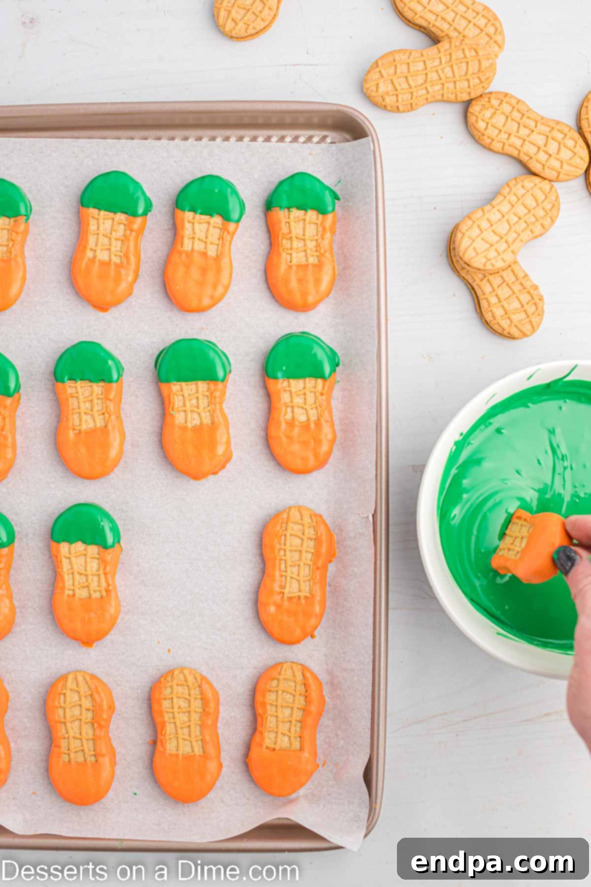 Lucky Leprechaun Bites 6 An orange-coated cookie being dipped into green candy melts to create the leprechaun's hat.