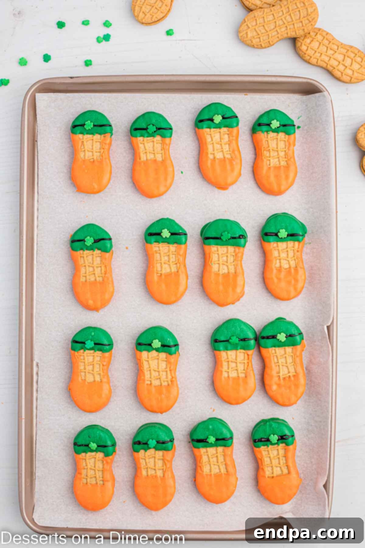 Lucky Leprechaun Bites 8 A leprechaun cookie being decorated with black icing for the hat brim and a shamrock sprinkle.