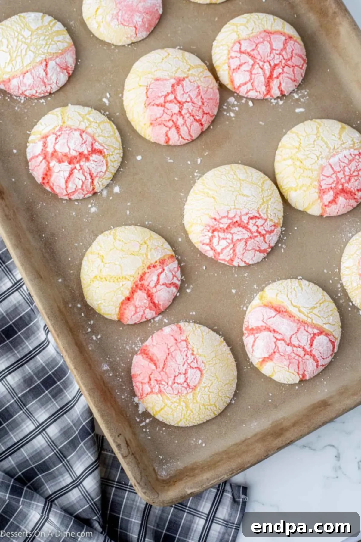 Tangy Strawberry Lemonade Cookies 8 Freshly baked Strawberry Lemonade Cookies cooling on a baking sheet directly out of the oven.