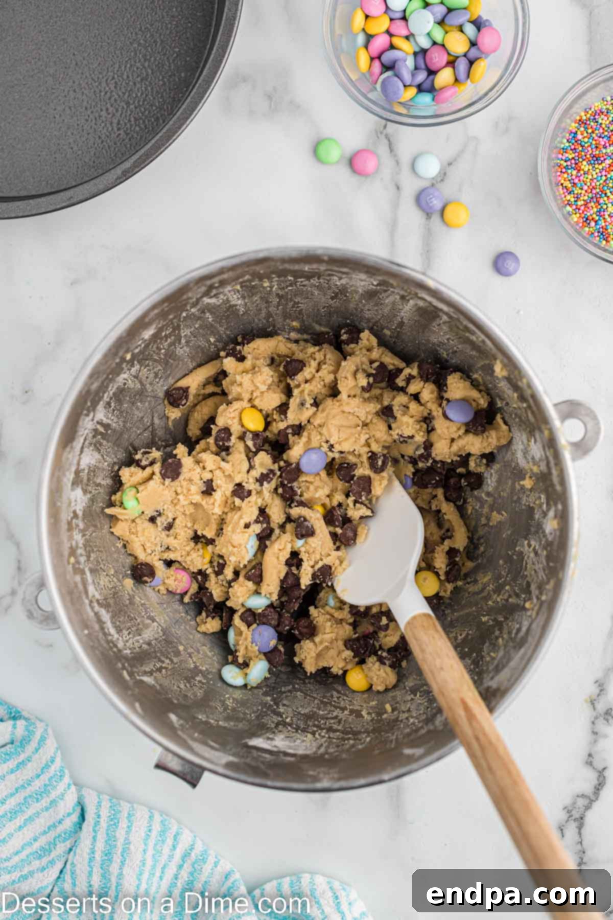 Chocolate chips and pastel M&M's folded into the prepared cookie dough