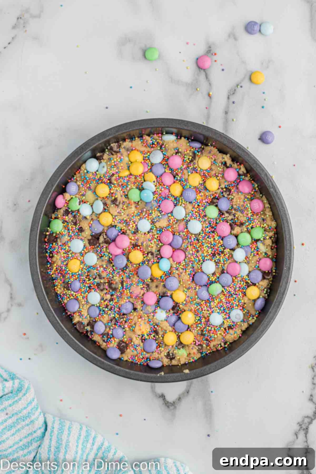 Remaining M&M's and sprinkles generously scattered over the cookie cake dough