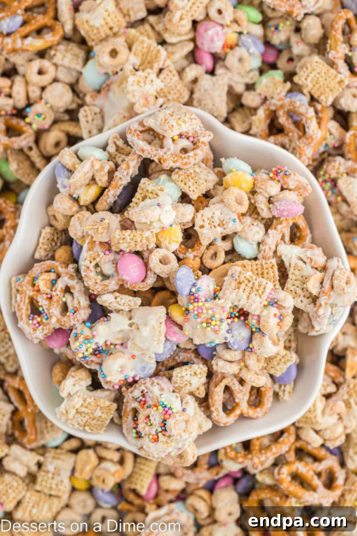 Bunny Magnet Mix 2 A bowl of vibrant Easter Bunny Bait, showcasing the colorful M&M's, pretzels, and cereal coated in white chocolate and sprinkles.