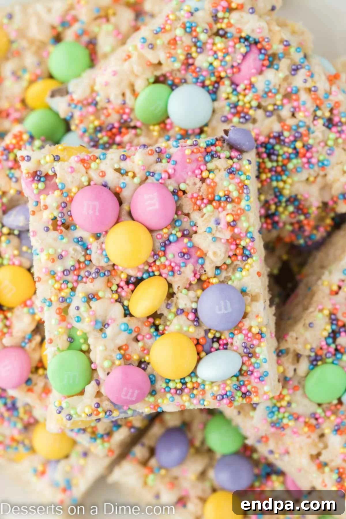 Springtime Krispie Delights 2 Easter Rice Krispie Treats cut into squares, showcasing pastel M&M's and sprinkles.