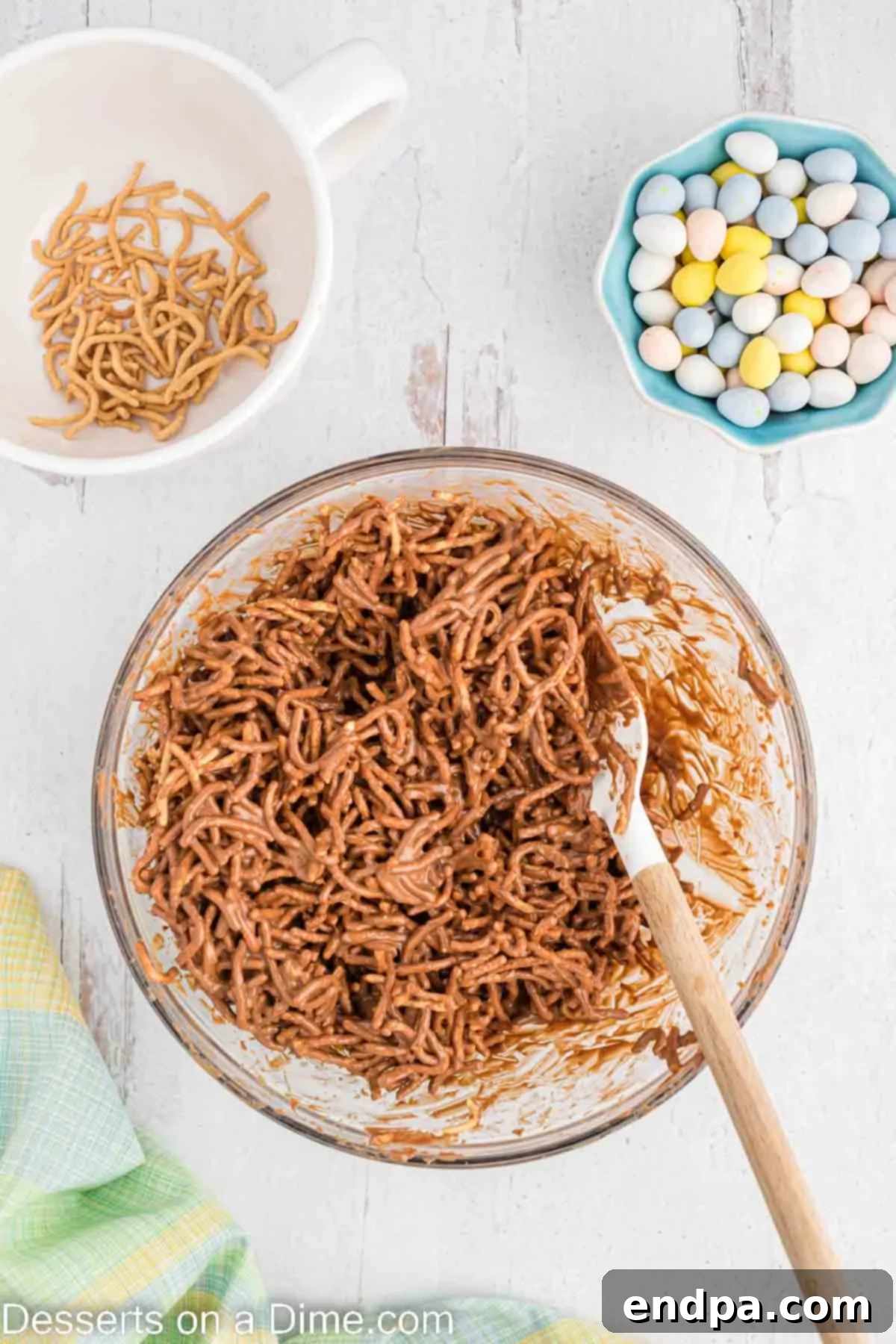 Chow mein noodles being mixed into the melted chocolate and peanut butter mixture.